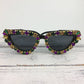 Sunglasses with colorful gemstones on a white wooden surface