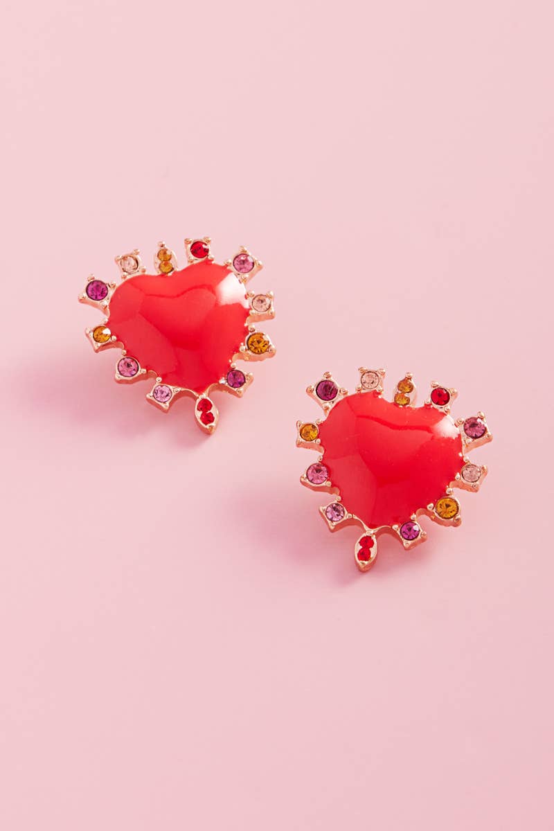 Heart-shaped earrings with gemstones on a pink background
