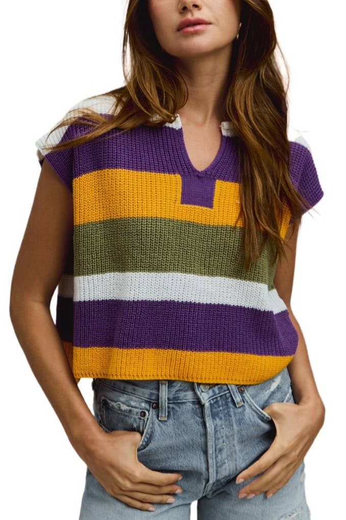 Woman wearing a colorful striped sleeveless sweater with a plain background