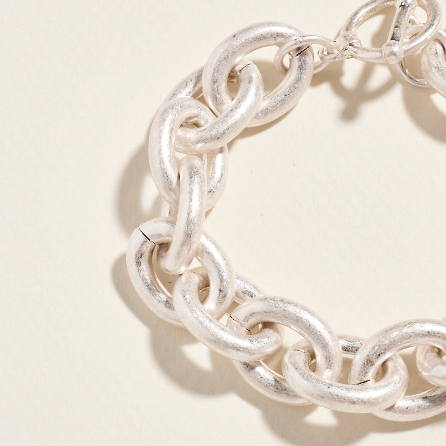 Silver chain bracelet on a beige background