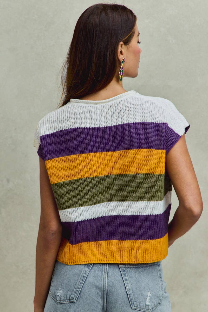 Woman wearing a colorful striped sweater against a neutral background