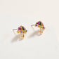 Colorful umbrella-shaped earrings on a light beige background