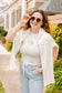 Woman wearing a white t-shirt with an oyster graphic design and pearl detail, 