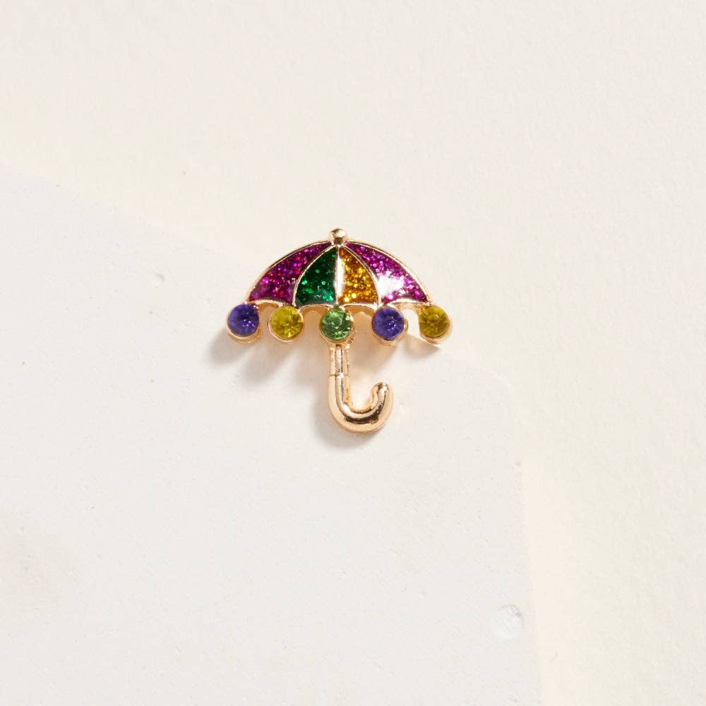 Colorful umbrella-shaped brooch on a light beige background