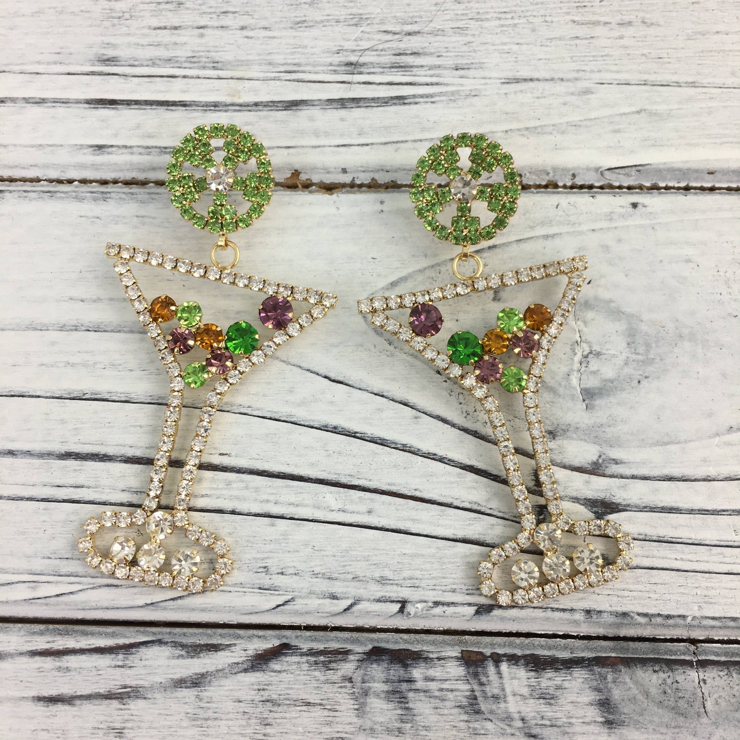 Pair of earrings with gemstones on a wooden surface