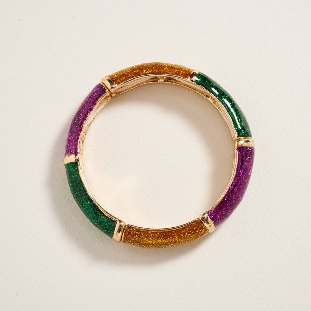 Multicolored ring with gold, green, and purple on a light gray background