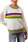 Beige sweater with colorful stripes worn by a person on a white background