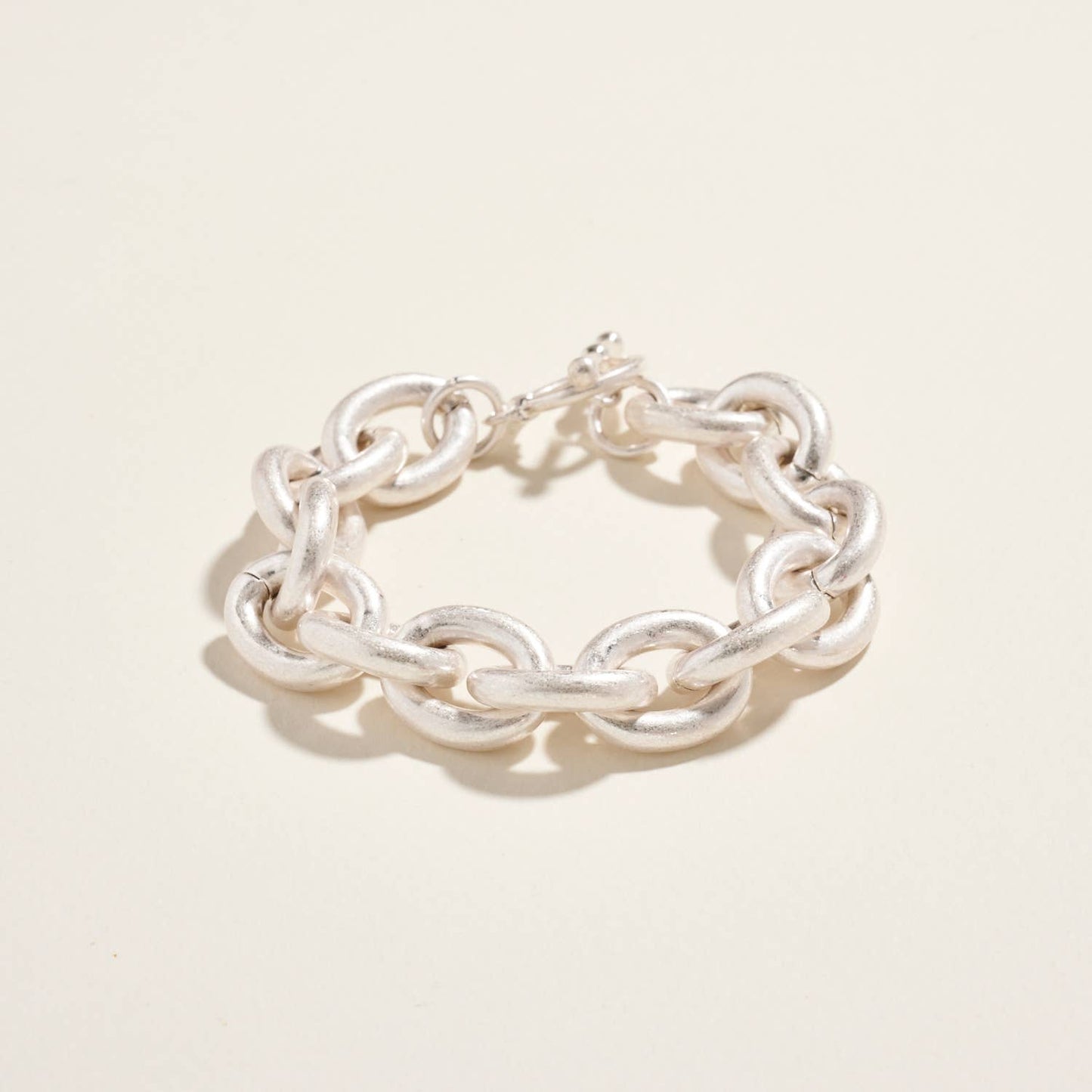 Silver chain bracelet on a light beige background