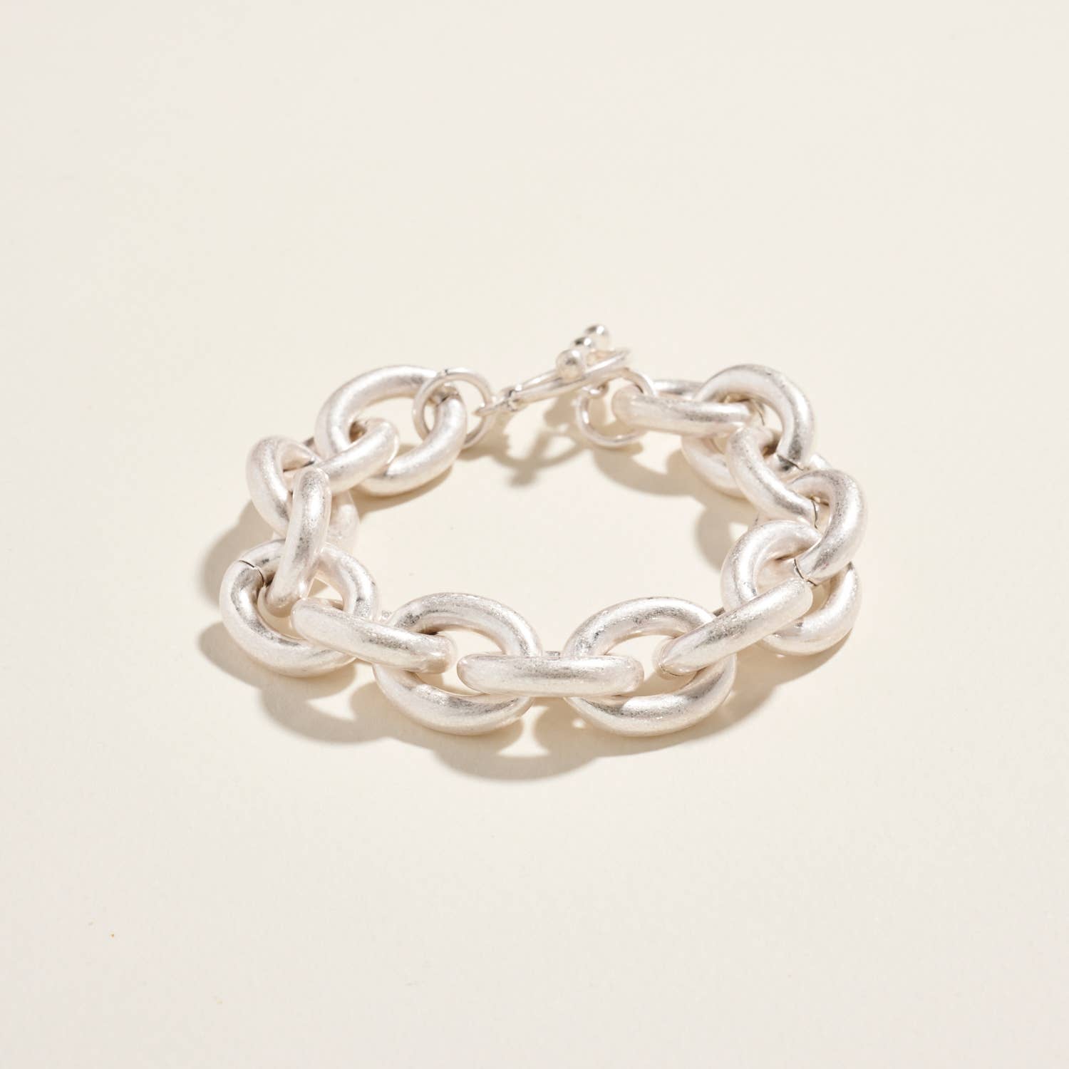 Silver chain bracelet on a light beige background