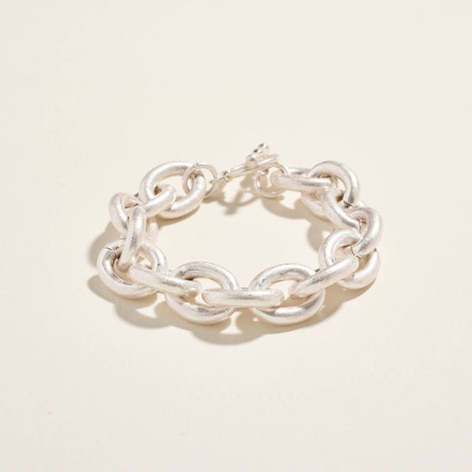 Silver chain bracelet on a light beige background