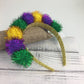 Colorful pom-pom headband on a wooden surface